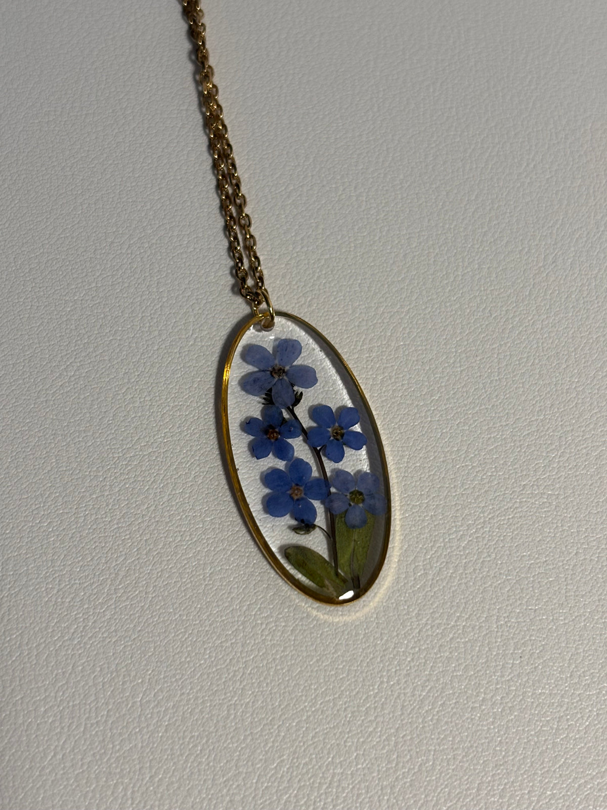 Collier ovale en résine avec fleurs de myosotis séchées