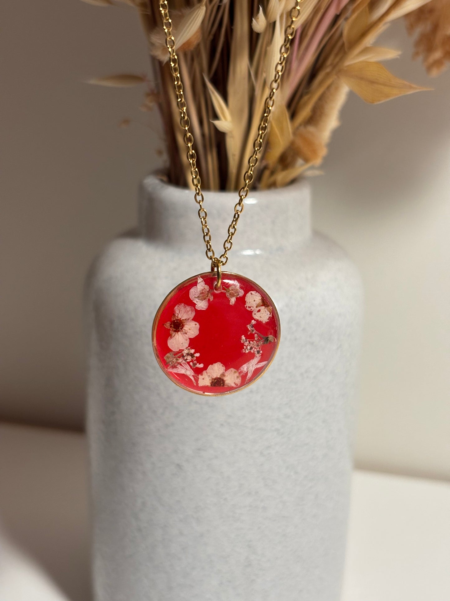 Collier couronne de fleurs séchées sur fond rouge transparent
