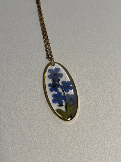 Collier ovale en résine avec fleurs de myosotis séchées