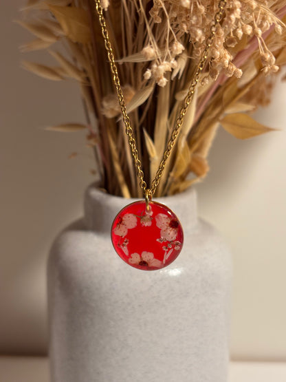 Collier couronne de fleurs séchées sur fond rouge transparent